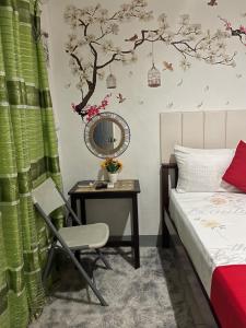 a bedroom with a bed and a table with a chair at YOO Darius' Residences in Moalboal