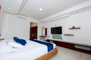 a bedroom with a bed and a flat screen tv at Hotel Ninfa in Puerto Ayora