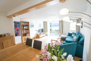 a living room with a blue couch and a table at Seascape at coed y berclas, luxury accommodation with stunning sea view in Llandegfan