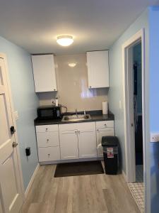 a kitchen with white cabinets and a sink at Cozy Studio in Quiet Neighborhood in Bradenton