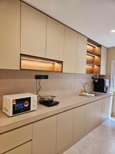 a kitchen with a microwave on a counter at Shmawai Homestay Tepi Sungai in Kota Tinggi +11 photos