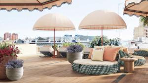 a patio with chairs and umbrellas on a roof at Áurea Palacio de la Tinta in Málaga