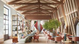 a restaurant with tables and chairs and windows at Áurea Palacio de la Tinta in Málaga