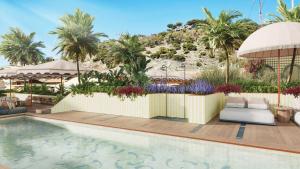 a pool at a resort with palm trees at Áurea Palacio de la Tinta in Málaga