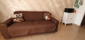 a brown couch with pillows in a living room at Oasi del mare in Fiumicino