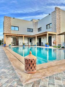 a building with a swimming pool in front of it at Chambre Agadir in Essaouira