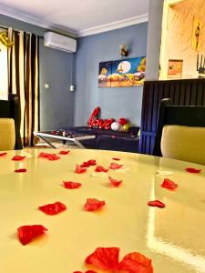 ヤウンデにあるAppartement meublé cosy et élégant - Yaoundé - Nsimalen - Bastos - Ambassade de Franceの赤いバラの花びらが乗ったテーブル +6枚の写真