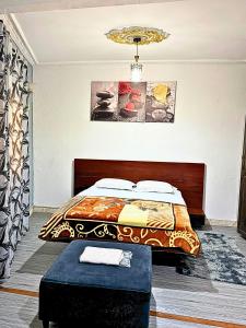 ヤウンデにあるAppartement meublé cosy et élégant - Yaoundé - Nsimalen - Bastos - Ambassade de Franceのベッドとテーブルのある寝室