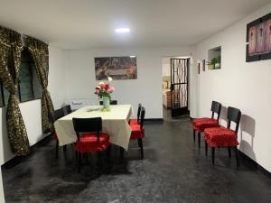 a dining room with a table and red chairs at HOSPEDAJE don VICTOR in Chancayllo