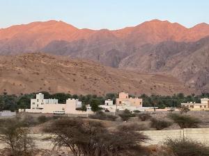 a group of white buildings in front of mountains at Sunset Views in Muscat