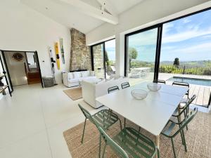 ラ・クロワ・ヴァルメにあるMagnifique villa avec piscine, vue merの白いテーブルと椅子のあるリビングルーム