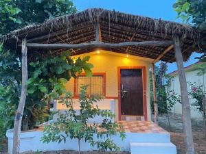 a small yellow house with a thatched roof at HOME in the JUNGLE in Seonī