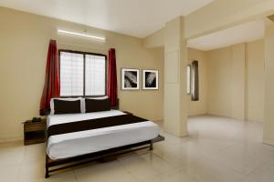 a bedroom with a large bed and a window at Hotel O Prarambh inn in Pune