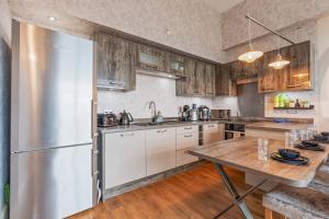 a kitchen with a stainless steel refrigerator and wooden cabinets at Brindley Apartment - City Centre - Free Parking, Fast Wifi and Smart TV by Yoko Property in Birmingham