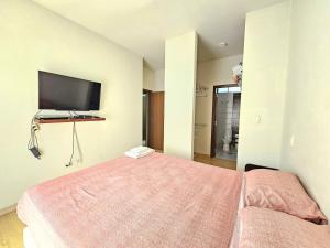 ein Schlafzimmer mit einem Bett und einem Flachbildfernseher in der Unterkunft Departamento de Dos dormitorios en el Corazón de Santa Cruz in Santa Cruz de la Sierra
