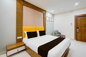 een slaapkamer met een groot bed in een kamer bij Townhouse OAK Hotel Vista Orchid in Tirupati +24 foto's