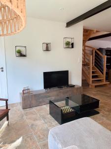 la ti breizh enchantée في Campénéac: غرفة معيشة مع أريكة وتلفزيون