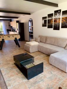 la ti breizh enchantée في Campénéac: غرفة معيشة مع أريكة وطاولة بلياردو