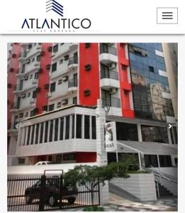 a tall building with a red and white at Atlantico Flat Santos in Santos