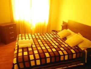 a bedroom with a bed with a checkered blanket at casa alameda Miraflores in Miraflores