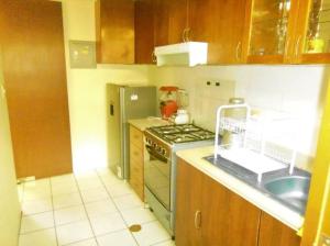 a kitchen with a stove and a refrigerator at casa alameda Miraflores in Miraflores