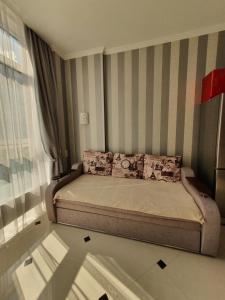 a small bedroom with a bed with striped walls at Квартира Аркадия ЖК жемчужина Кадора 10 мин от моря in Odesa