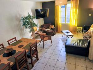 a living room with a table and a couch at 3 Gites- Le Roosevelt, Côte 204, Côte 204 Bis in Château-Thierry