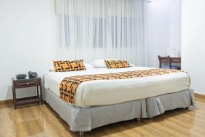 a bedroom with a large bed with two pillows at Hotel Kamani Florencia in Florencia +59 photos