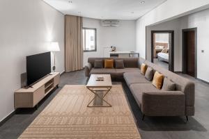Sulţānahにあるالاورفلي للوحدات السكنيةのソファとテレビのあるリビングルーム