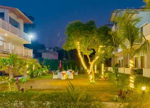 a courtyard with a table and a tree with lights at Creek Nest Resort in Rāmnagar