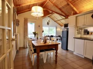 a kitchen and dining room with a wooden table at Coeur de Biche in Rendeux