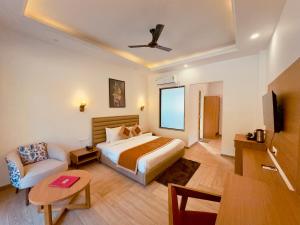 a hotel room with a bed and a couch at Creek Nest Resort in Rāmnagar +7 photos
