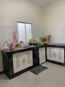 a kitchen with a counter top and a sink at kubu home stay in Ban Ko Sawat