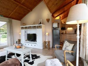 a living room with a table and a tv at Coeur de Biche in Rendeux