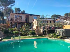 a house with a swimming pool in front of a yard at Chalet Nanou in La Ciotat