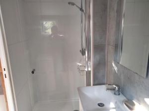 a white bathroom with a shower and a sink at Chalet Nanou in La Ciotat