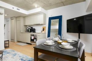 a dining room with a table with chairs and a television at Chic Hideaway - Downtown Hotspot in Montreal