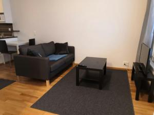 a living room with a couch and a coffee table at Convenient Studio for 1 with Sauna in Kemi