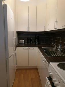 a kitchen with white cabinets and a sink at Convenient Studio for 1 with Sauna in Kemi +7 photos