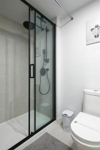 a bathroom with a glass shower with a toilet at Chic Hideaway - Downtown Hotspot in Montréal
