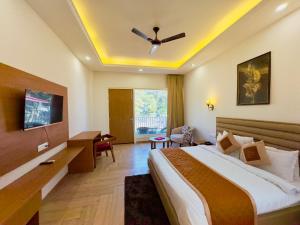 a hotel room with a bed and a ceiling fan at Creek Nest Resort in Rāmnagar
