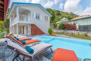 a villa with a swimming pool and a house at Villa Rose Du Désert in Sainte-Anne