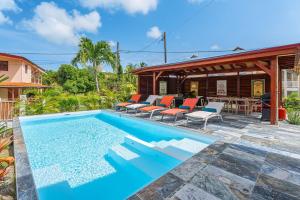 a swimming pool in front of a house at Villa Rose Du Désert in Sainte-Anne