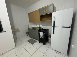 eine weiße Küche mit einem Kühlschrank und einer Spüle in der Unterkunft Apartamento Flat 303 COP30 in Belém