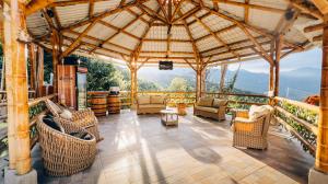 a large wooden gazebo with chairs and tables at Glamping Villa Pedregal in La Gran Via