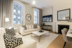 ein Wohnzimmer mit weißen Möbeln und einem Kamin in der Unterkunft Premier 3 Bed Luxury Apartment in Covent Garden in London
