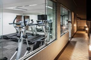 un gimnasio con varias cintas de correr y espejos en Normandy Hotel, en Belo Horizonte