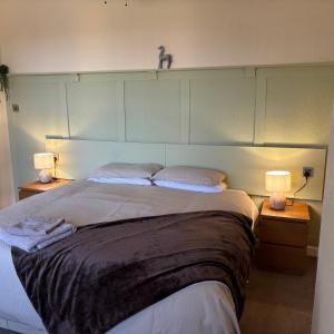 a bedroom with a large bed with two lamps at The Hawthornes Licensed Guest House in Knottingly