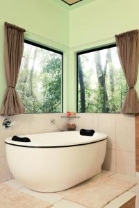 a white bath tub in a bathroom with a window at Pousada Kaporã in Bocaiúva do Sul