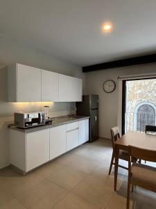 a kitchen with white cabinets and a table and a window at Morada Living in Guadalajara